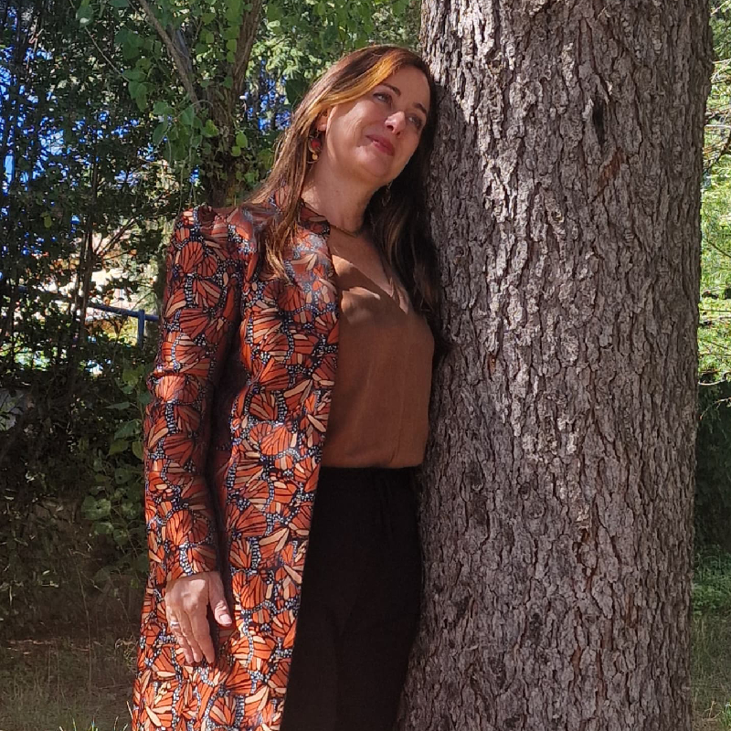 Paz Endrino junto a un árbol